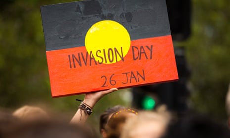 A protestor holds a sign during an Invasion Day march through Melbourne on 26 January.