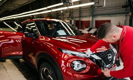 A worker at Nissan’s Sunderland factory inspects a red SUV