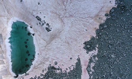 An aerial picture taken above the Presena glacier near Pellizzano, shows pink coloured snow