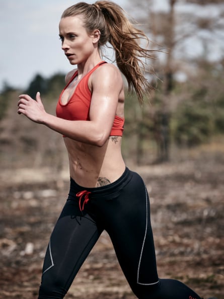 Woman with her long hair pulled back in a ponytail jogging in a sports bra and running tights