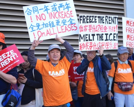 Demonstrators hold placards that read: ‘NO INCREASE ON ALL LEASES’ and ‘FREEZE THE RENT, MELT THE I.C.E.’