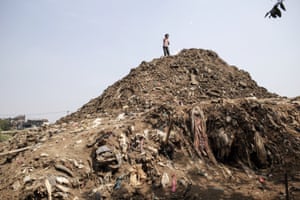 A child flies a kite on a mountain of sediment taken out of the Citarum in Dayeuhkolot.
