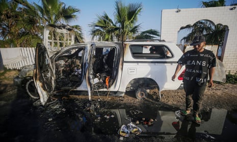 A man stands near a destroyed car of the NGO World Central Kitchen