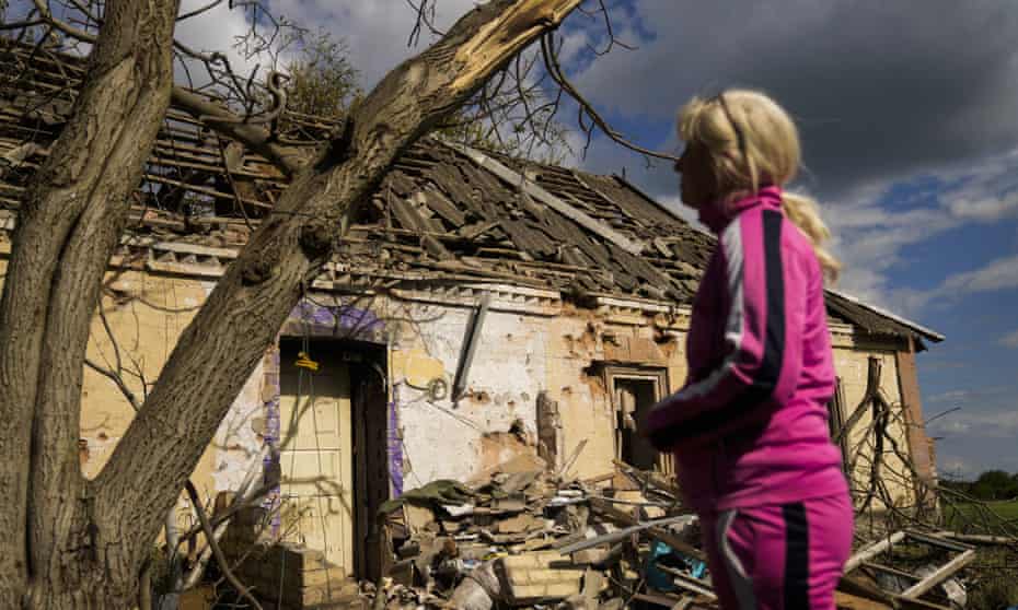 Iryna Martsyniuk, 50, stands next to her heavily damaged house after Russian bombing in Velyka Kostromka village, Ukraine