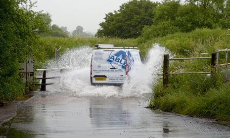 A motorist negotiates a  flooded road after torrential rain in Buttsbury, Essex
