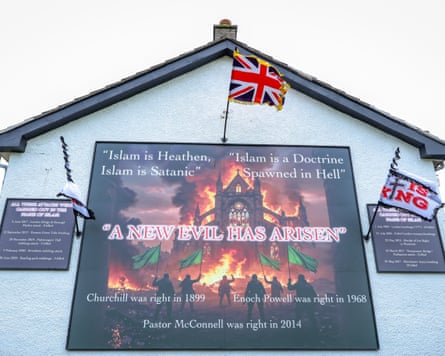 Anti-Islamic murals on the side of a building in Newtownabbey outside Belfast with a union flag flying above it.