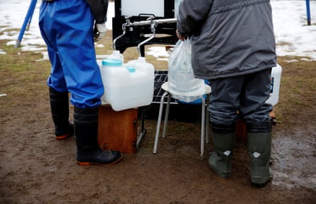 Residents fill up bottles from the communal water tank for Noto earthquake survivors in Suzu, Ishikawa prefecture, on 30 January.