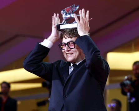 Ilya Khrzhanovsky smiles as he balances the Silver Lion award between his hands on his head