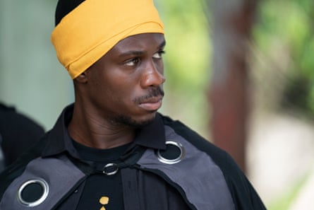 A young man with a yellow scarf wrapped round his head