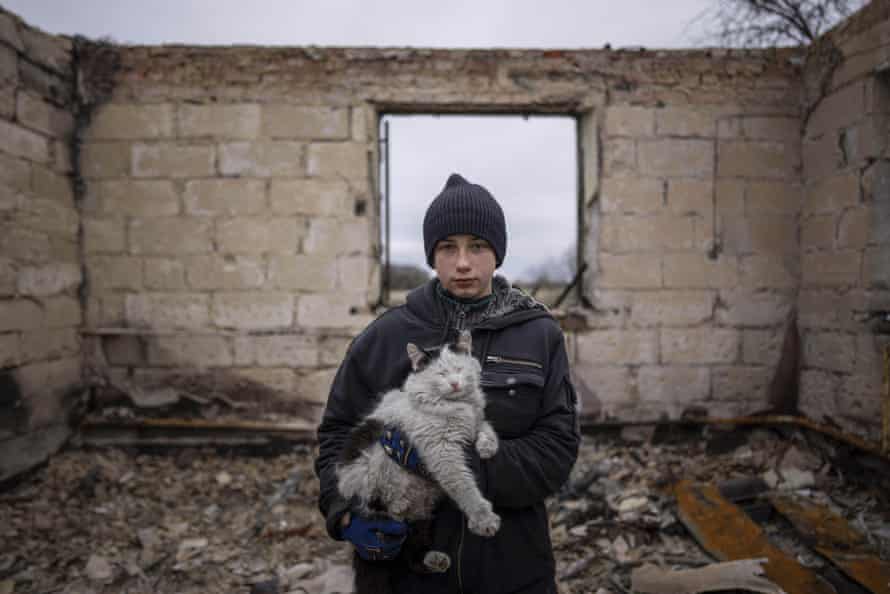 Danyk Rak, 12, holds a cat standing on the debris of his house destroyed by Russian forces’ shelling in the outskirts of Chernihiv, Ukraine.