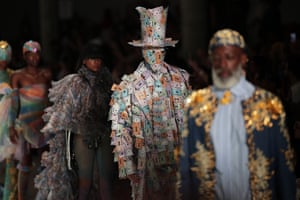 A model plastered from head to foot in Monopoly money takes to the catwalk