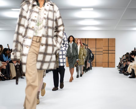 A line of models in Burberry check coats and more walks between two lines of seated viewers