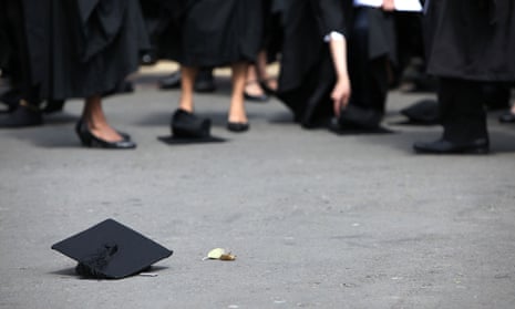 Students stand beside mortarboards thrown on the floor