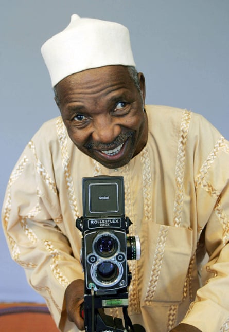 Malick Sidibé, smiling, with camera