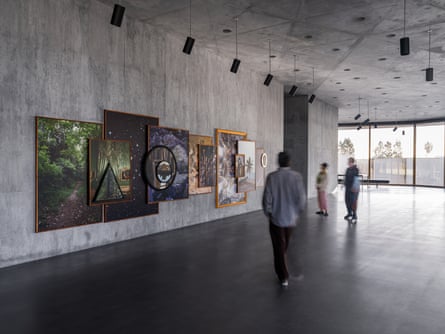 Paintings are displayed on concrete walls in a large gallery space.