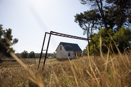 Rusted monkey bars frame the chapel with brown grass and trees visible around