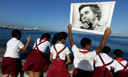 Students carry a photograph of Che Guevara at Havana’s seafront Malecón.