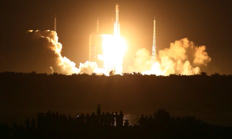 Spectators watch as a Long March-7 rocket lifts off the launch pad in China’s Hainan Province on 25 June.