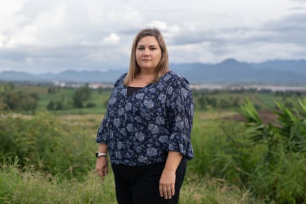 A white woman in a blue blouse stands in a field