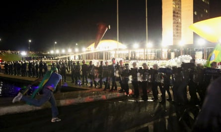 A demonstrator throws a cone against police officers during a protest in Brasilia.
