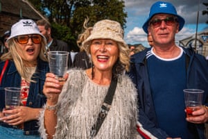 Smiling fans wearing bucket hats and holding drinks.
