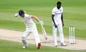 England’s Dom Sibley celebrates his century as West Indies’ Alzarri Joseph looks on.