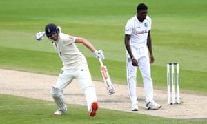 England’s Dom Sibley celebrates his century as West Indies’ Alzarri Joseph looks on.