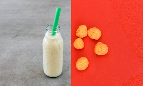Fizzy milk in a glass bottle with a green straw, and cheesy balls on a red backgroundComposite Dairy and carbs