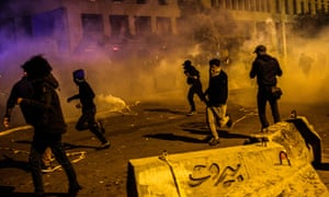 Protesters flee tear gas in clashes with security forces in Beirut on Saturday.