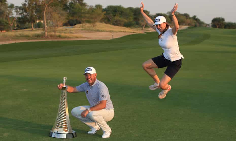 Lee Westwood’s girlfriend and caddie, Helen Storey, joins in the celebrations as he poses with the Race to Dubai trophy