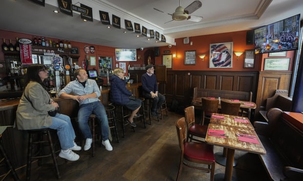 Des personnes assistent aux funérailles de la Reine au pub Cricketer à Paris.