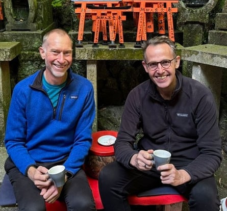 David McLean and Paul Heath at a cafe near Fushimi Inari Taisha shrine in Kyoto, Japan. They are holding coffee cups and wearing quarter-zip polar fleece jumpers.