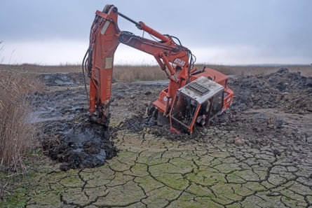 An excavator machine sinking in degraded wetland in the Danube Delta Biosphere Reserve