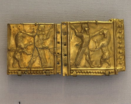 Rectangular gold artefact showing man fighting lion.