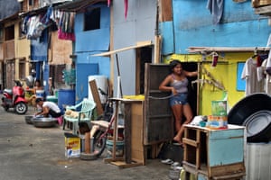 Angelina Domingo, 18, poses at the door threshold of her shanty in Delpan slum, Binondo district, Manila.