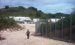 A guard walks towards the entrance of the Nauru detention centre. 
