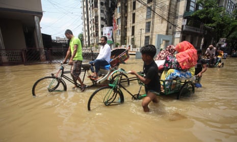 Rickshaw riders at work on a flooded street in Sylhe, Bangladesh