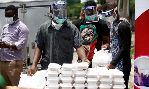 Volunteers wearing face shields distribute food in Lagos, Nigeria, where improving the level of testing has been difficult.