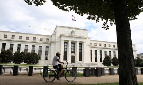 A cyclist passes the Federal Reserve building in Washington DC.
