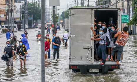People navigate flooded streets after heavy monsoon rain in Rizal, the Philippines.
