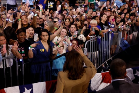a woman waves to a crowd of people