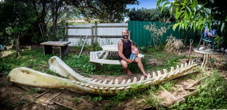Buck Cullen with his daughter Kaiarahi (10 months) in his back yard where he is storing a pair of massive Sperm Whale jawbones. Buck is a integral member of the whale recovery team, alongside Hori Parata.