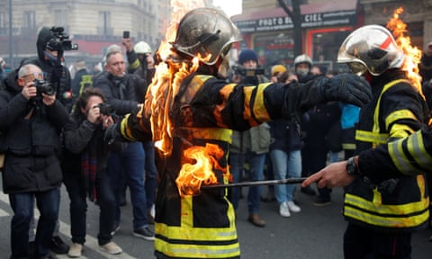 Firefighters simulate setting themselves on fire during the protest in Paris