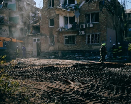 Rescue workers clear rubble at the site of a Russian hit on Boryspilska Street in Kyiv