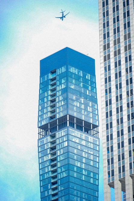 Plane flying above a blue skyscraper building
