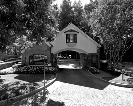 A hut-like structure above a tree-lined driveway
