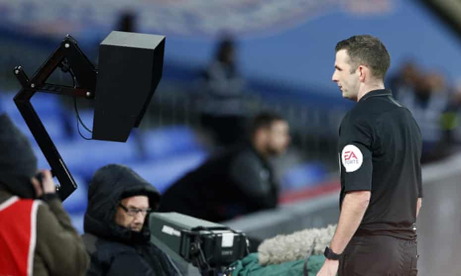 Referee Michael Oliver checks the VAR monitor by the side of the pitch before dismissing Luka Milivojevic.