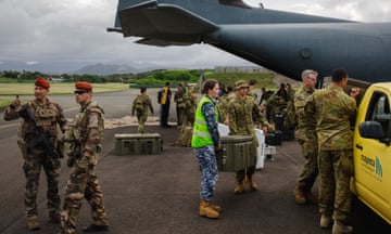 An ADF handout photo showing defence force and Dfat personnel assisting people boarding an evacuation flight in New Caledonia