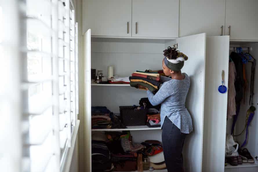 A woman carefully putting away neatly folded clothes