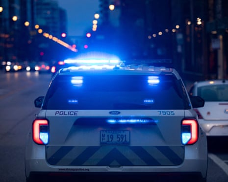 back of chicago police car parked on street with lights on at night